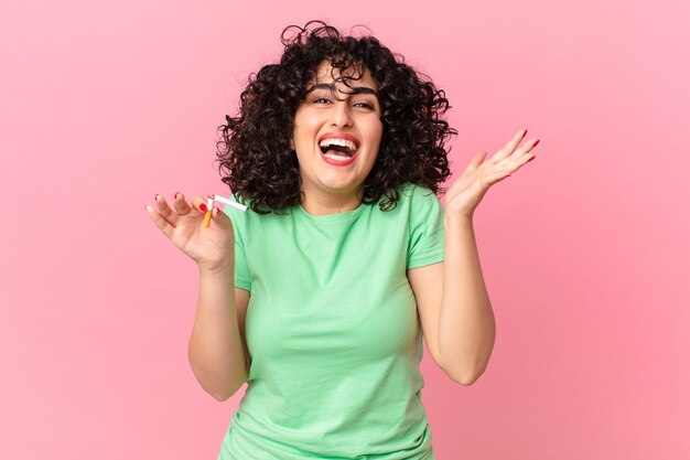 Mulher bonita árabe se sentindo feliz e surpresa com algo inacreditável. conceito de não fumar