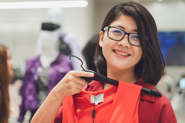 Foto mulher bonita asiática escolha para comprar um novo conjunto adequado para temporada, temporada