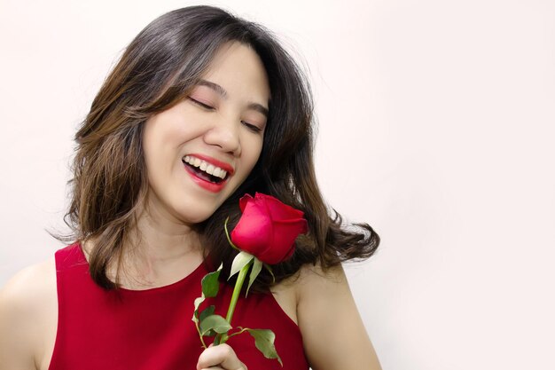 Mulher bonita asiática que está feliz recebendo rosa vermelha em um dia dos namorados com sorriso