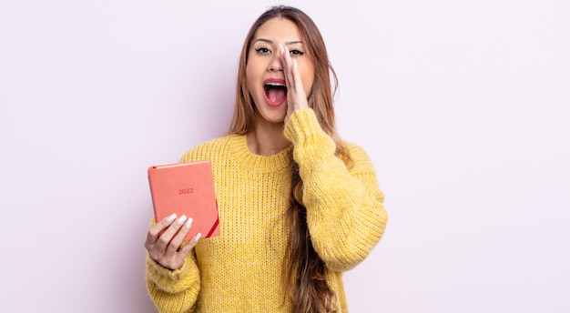 Mulher bonita asiática se sentindo feliz, dando um grande grito com as mãos perto da boca. conceito de agenda