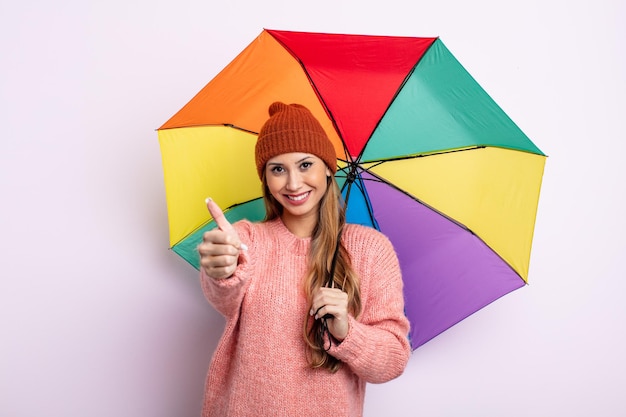 Mulher bonita asiática se sentindo orgulhosa, sorrindo positivamente com o polegar para cima. conceito de guarda-chuva