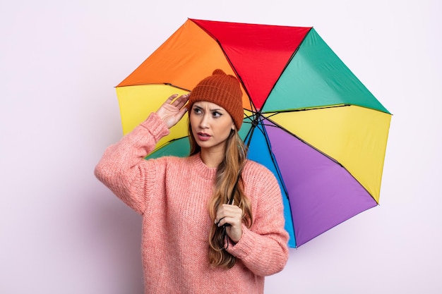 Mulher bonita asiática se sentindo perplexa e confusa, coçando a cabeça. conceito de guarda-chuva