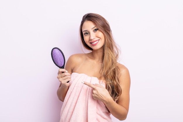 Mulher bonita asiática sorrindo alegremente, se sentindo feliz e apontando para o lado. conceito de cuidado de cabelo