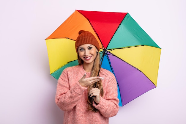 Mulher bonita asiática sorrindo alegremente, sentindo-se feliz e mostrando um conceito. conceito de guarda-chuva