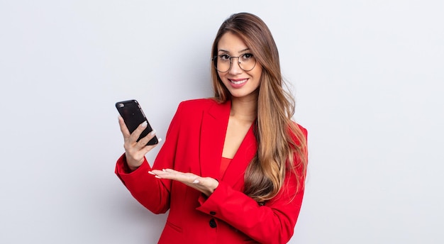 Mulher bonita asiática sorrindo alegremente, sentindo-se feliz e mostrando um conceito. conceito de negócios e telefone.