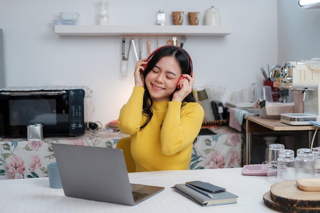 Mulher bonita asiática sorrindo em casa com fones de ouvido menina ouvir música em casa usar tecnologia conceito de estilo de vida