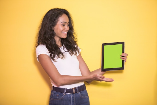 Mulher bonita asiática sorrindo enquanto apresenta tablet com tela verde