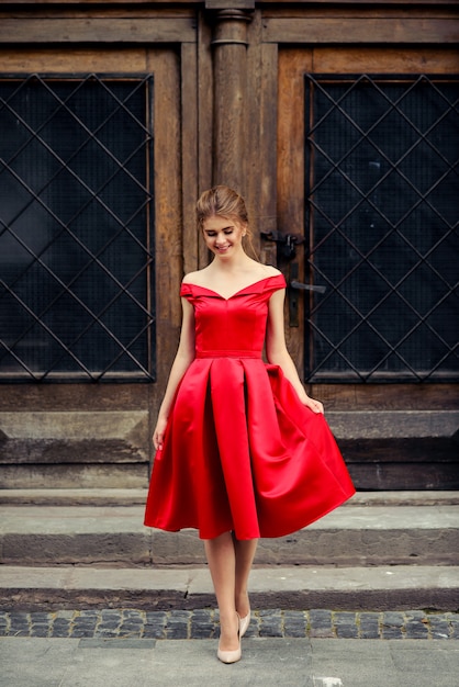 Mulher bonita atraente vestido vermelho na cidade velha porta vintage