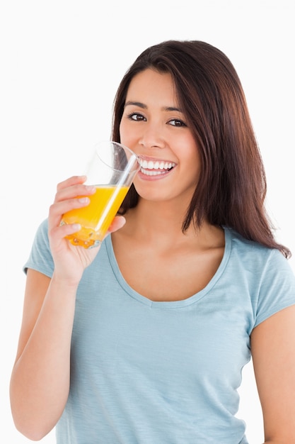 Mulher bonita bebendo um copo de suco de laranja