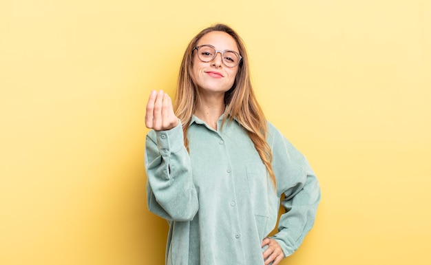 Mulher bonita caucasiana fazendo gesto de capice ou dinheiro dizendo para você pagar suas dívidas