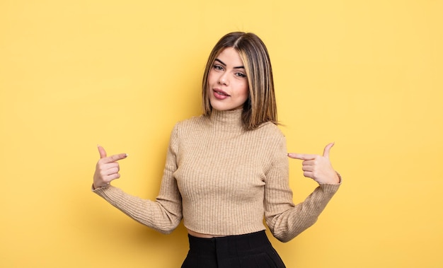 Mulher bonita caucasiana parecendo orgulhosa, arrogante, feliz, surpresa e satisfeita, apontando para si mesma, sentindo-se uma vencedora