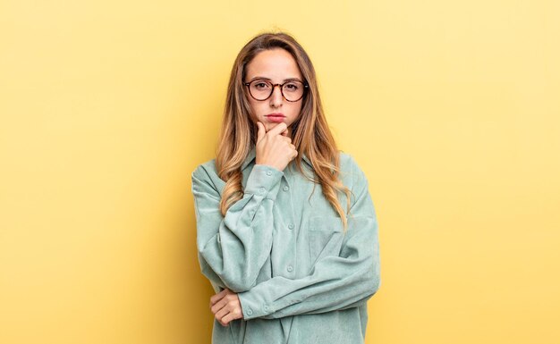 Mulher bonita caucasiana parecendo séria, confusa, incerta e pensativa, duvidando de opções ou escolhas