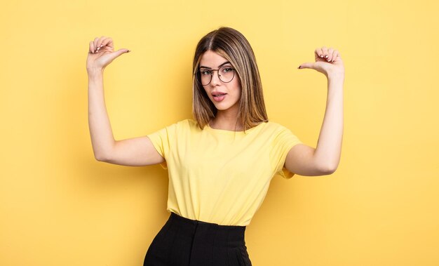 Mulher bonita caucasiana se sentindo orgulhosa, arrogante e confiante, parecendo satisfeita e bem-sucedida, apontando para si mesma