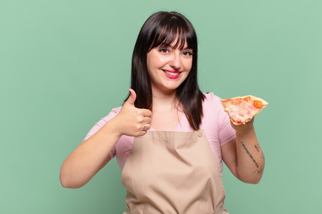 Mulher bonita chef com uma expressão feliz e segurando uma pizza