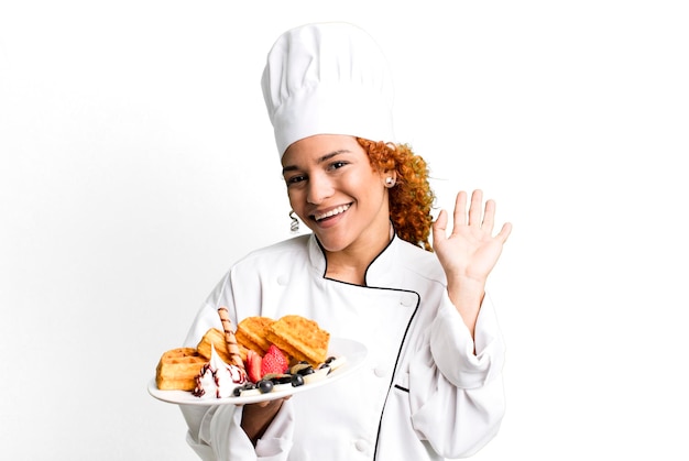 Foto mulher bonita chef de cabelo ruivo cozinhando waffles
