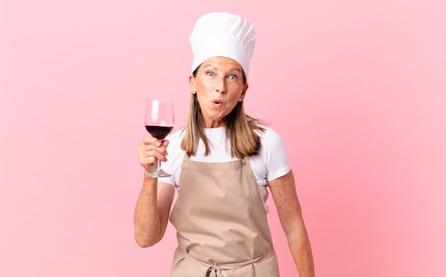 Mulher bonita chef de meia-idade com uma taça de vinho