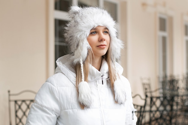 Mulher bonita com a jaqueta de inverno olhando perto do prédio