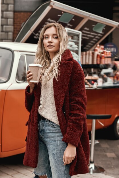 Mulher bonita com cabelo comprido posando e bebendo café