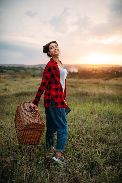 Mulher bonita com cesta, piquenique no campo de verão. Viagem romântica, feliz fim de semana