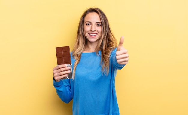 mulher bonita com chocolate contra parede isolada