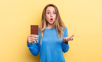 Foto mulher bonita com chocolate contra parede isolada