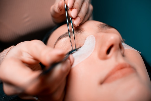 Foto mulher bonita com cílios longos em um salão de beleza. procedimento de extensão dos cílios. cílios close-up