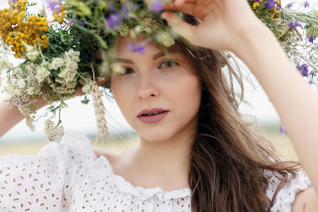 Mulher bonita com coroa de flores na cabeça.