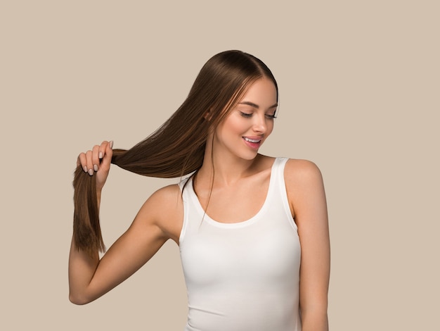 Mulher bonita com estilo casual de beleza de cauda de cabelo longo liso saudável. cor de fundo marrom