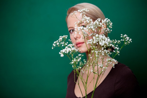 Mulher bonita com flor gypsophila em cena verde