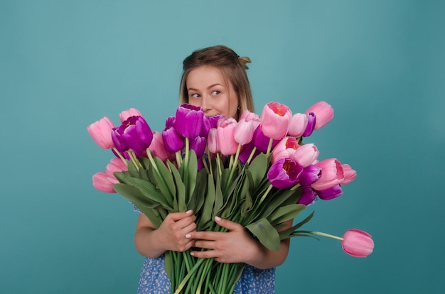 Mulher bonita com flores. Bela jovem com ramo de flores nas mãos dela. Férias de primavera e verão. Dia da Mulher. Beleza, conceito de moda.