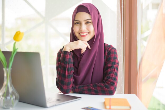 Mulher bonita com hijab na mesa dela