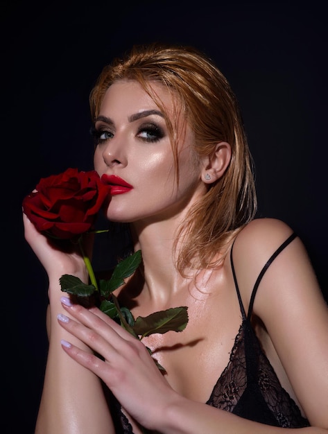 Mulher bonita com lábios vermelhos e maquiagem de moda com rosas posando em beleza de estúdio e retrato de moda