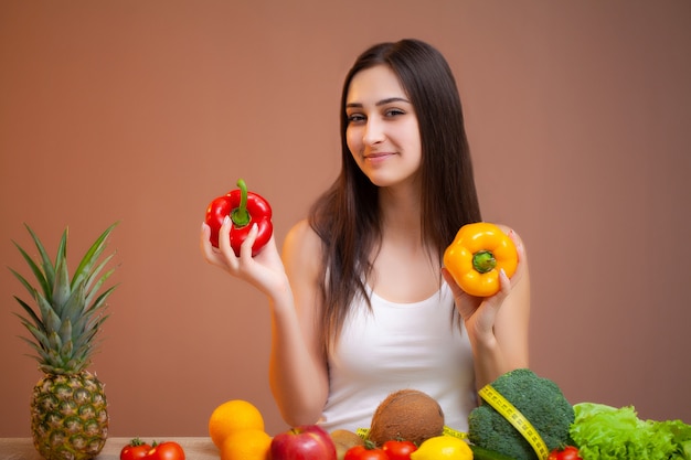 Mulher bonita com legumes frescos e frutas, levando um estilo de vida saudável