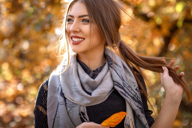 Foto mulher bonita com lenço cinza no outono