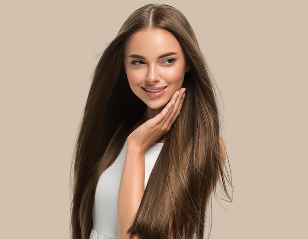 Foto mulher bonita com mãos lindas, cabelo longo liso voador em vestido branco cor de fundo marrom