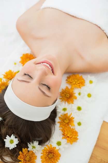 Mulher bonita com os olhos fechados e flores no salão de beleza