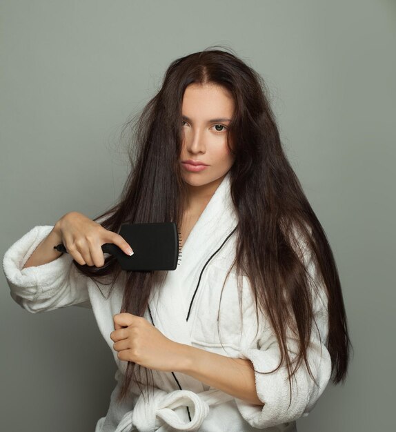 Mulher bonita com pente em fundo branco cuidado de cabelo e problema de cabelo