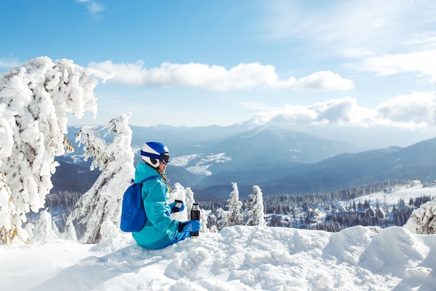 Mulher bonita com roupas de inverno, bebendo chá nas montanhas. conceito de viagem, lazer, liberdade, esporte.