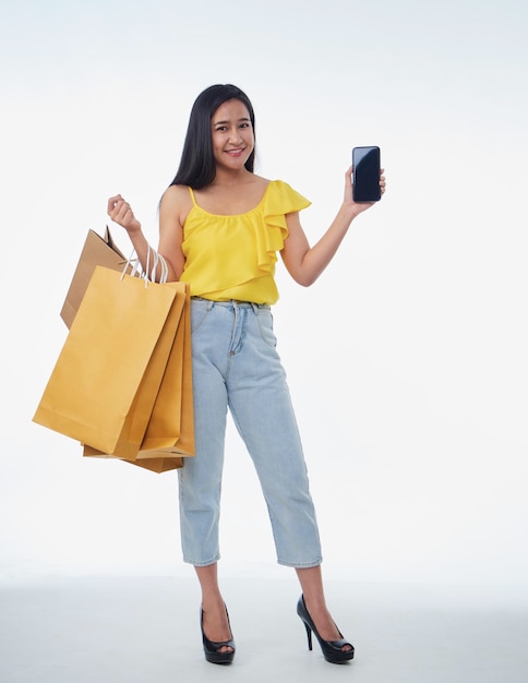 Mulher bonita com sacolas de compras e smartphone