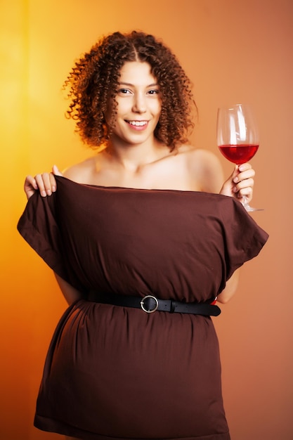 Mulher bonita com um copo de vinho tinto participar do desafio de travesseiro.