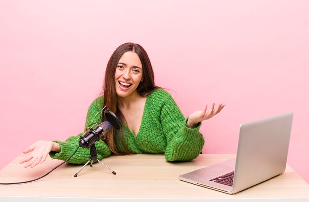 Mulher bonita com um laptop e um conceito freelance de rede social de microfone