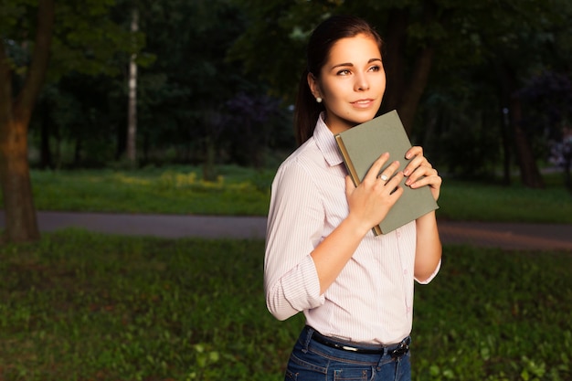 Foto mulher bonita com um livro no parque