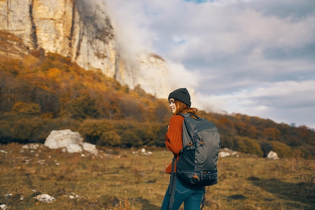 Foto mulher bonita com uma mochila no outono nas montanhas jeans chapéu de lazer relaxar foto de alta qualidade