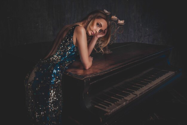 Mulher bonita com vestido elegante, posando na sala de piano