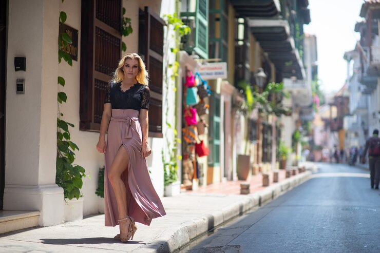 Foto mulher bonita com vestido longo caminhando sozinha pelas ruas coloridas da cidade colonial murada de cartagena. colômbia.