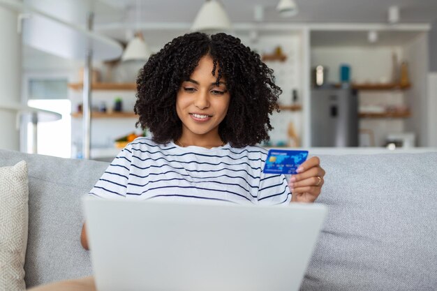 Mulher bonita comprando on-line com cartão de crédito mulher segurando cartão de credito e usando laptop conceito de compras on-line