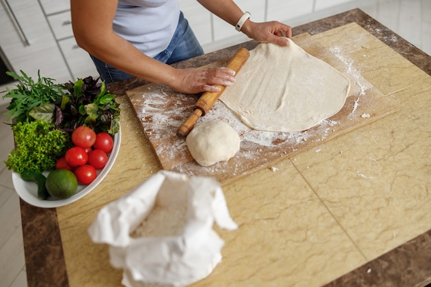 Mulher bonita cozinhando pratos deliciosos na cozinha de sua casa