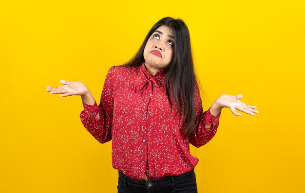 Mulher bonita curiosa com expressão feliz isolada em fundo amarelo