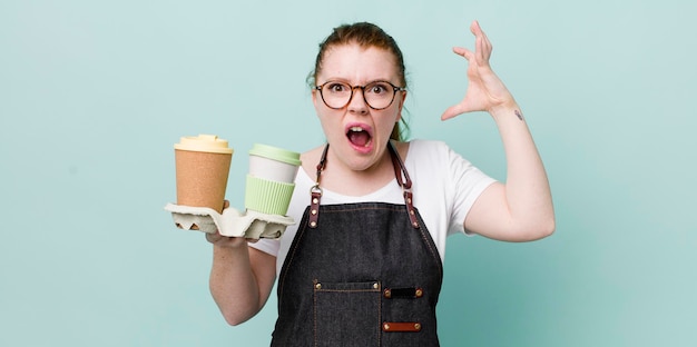 Mulher bonita de cabeça vermelha gritando com as mãos no ar tirar o conceito de café