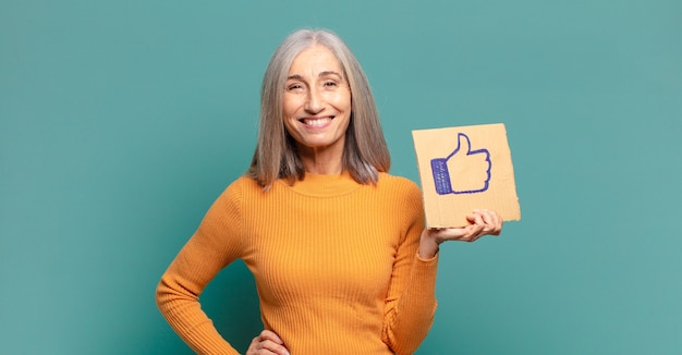 Mulher bonita de cabelo grisalho segurando uma mídia social como um banner
